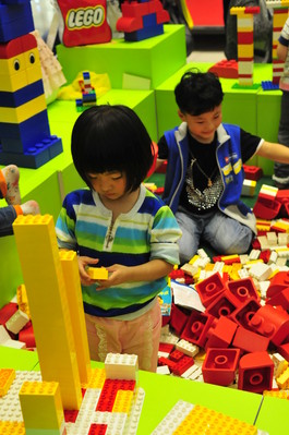 小朋友沉浸在樂高積木的世界里，專心致志地拼搭自己的作品。